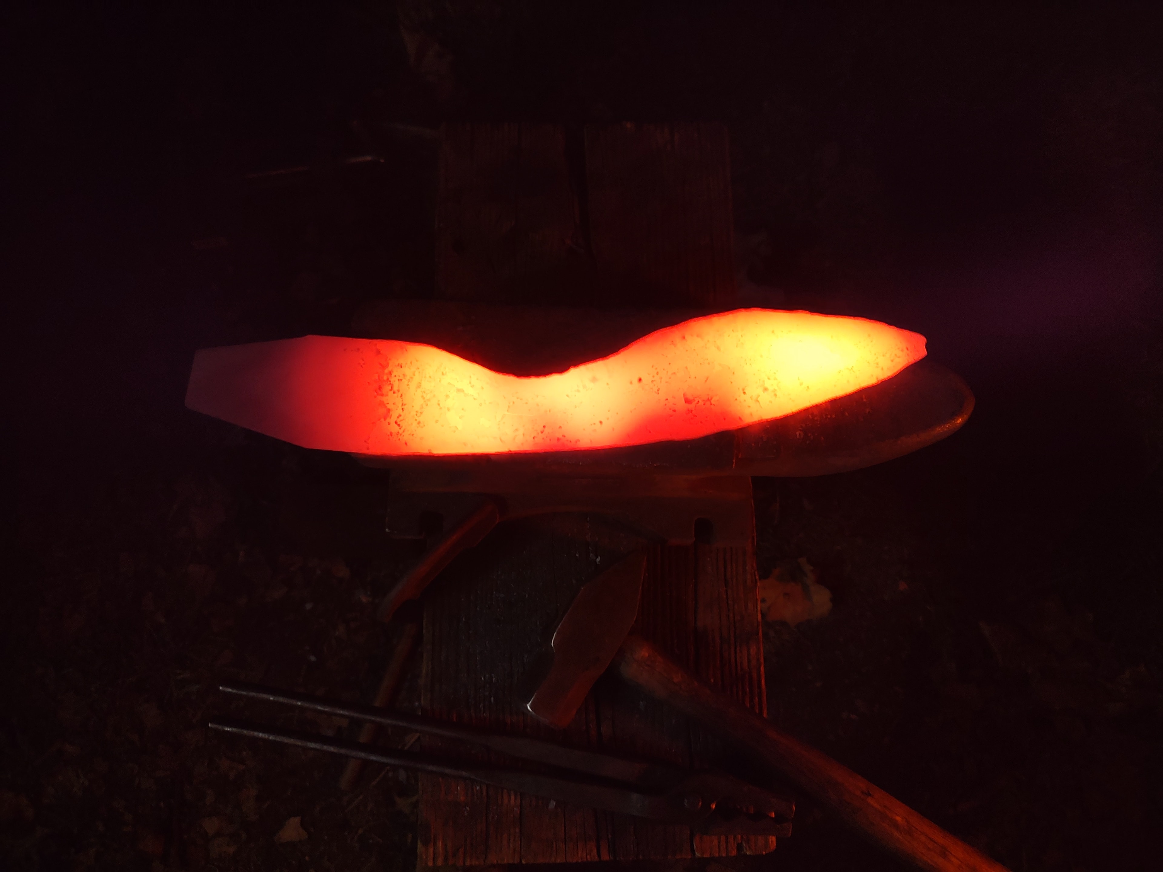 Glowing steel blank on the anvil