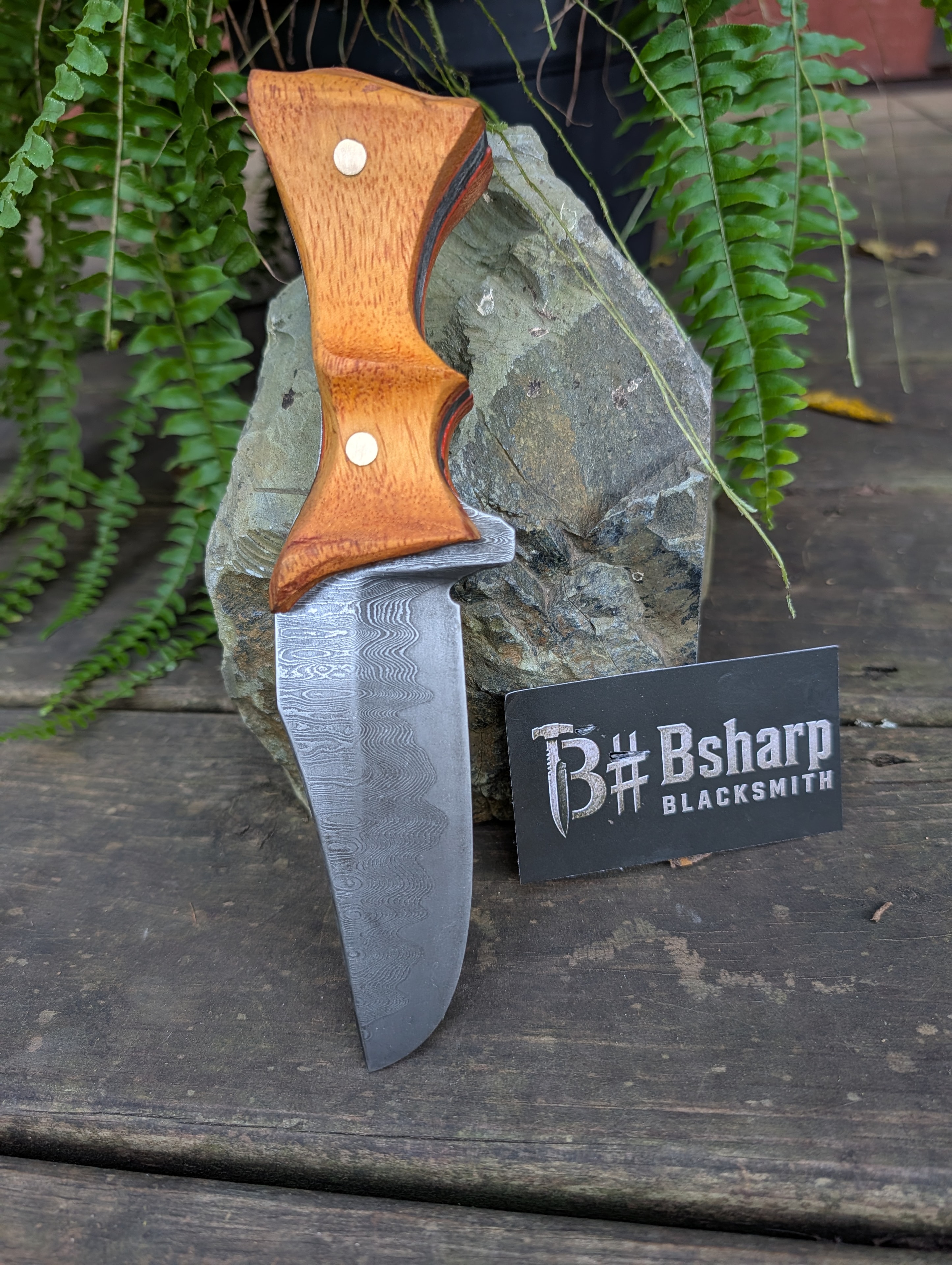 Damascus hunter resting on stone with Bsharp Blacksmith card