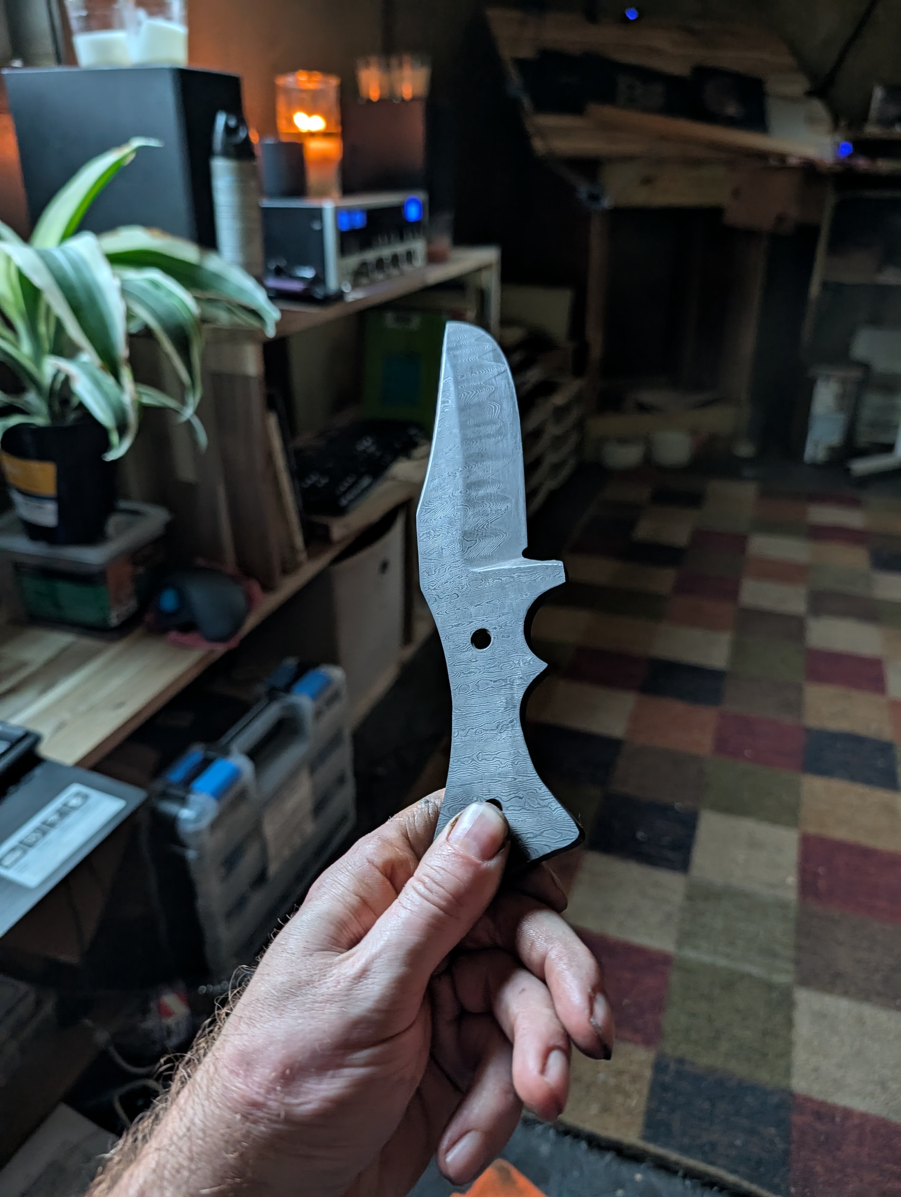 Damascus blade blank held in workshop