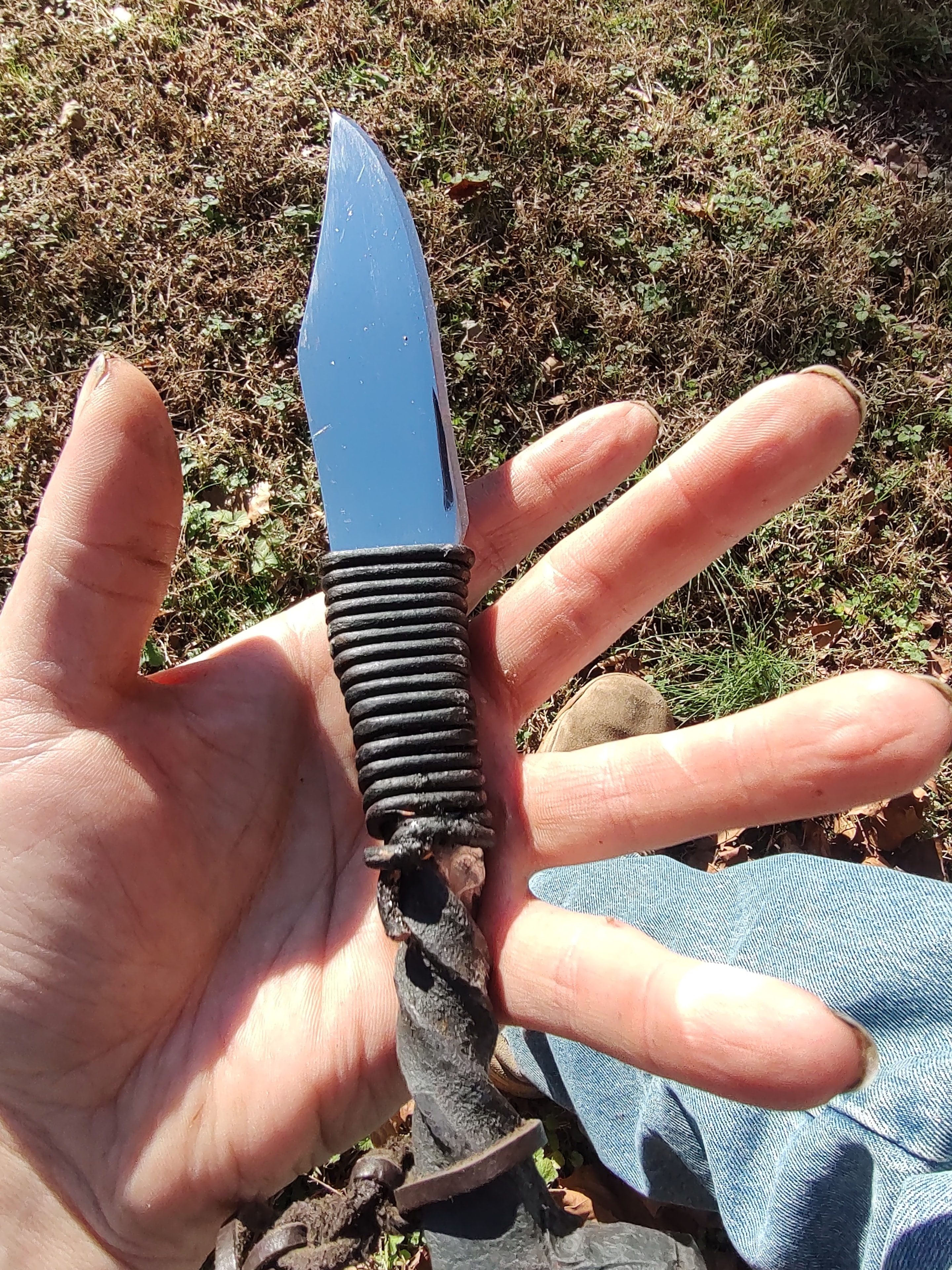 Fixed blade knife with blue handle outdoors