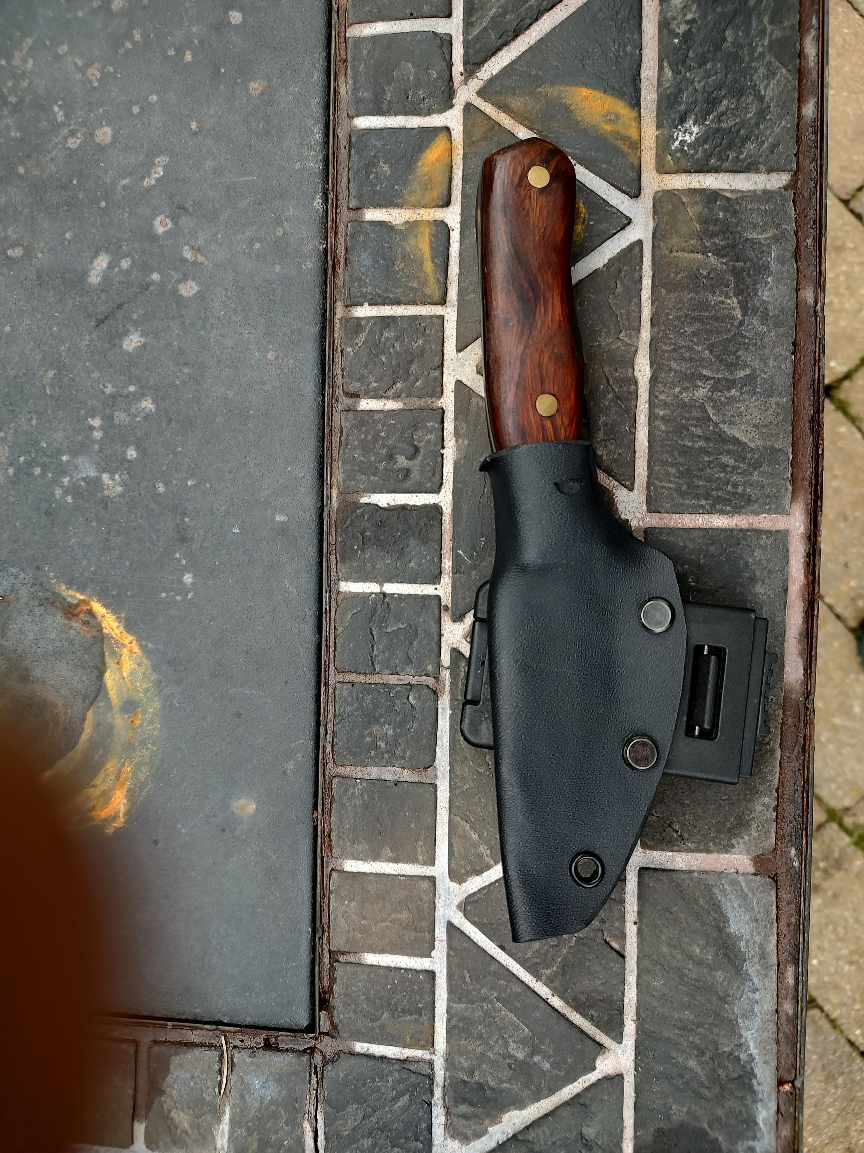 Hunting knife with wooden handle on brick