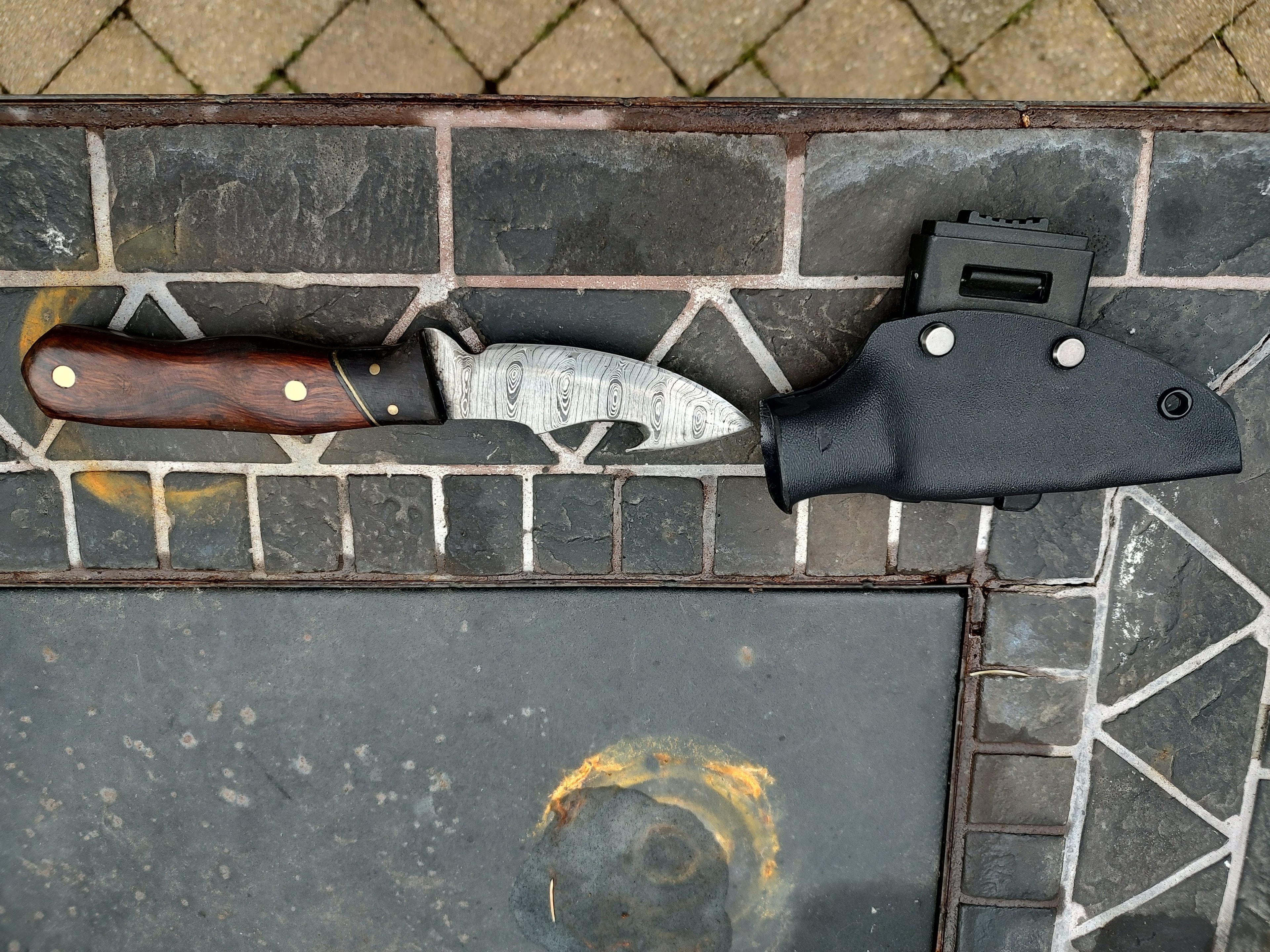 Hunting knives with sheaths on brick
