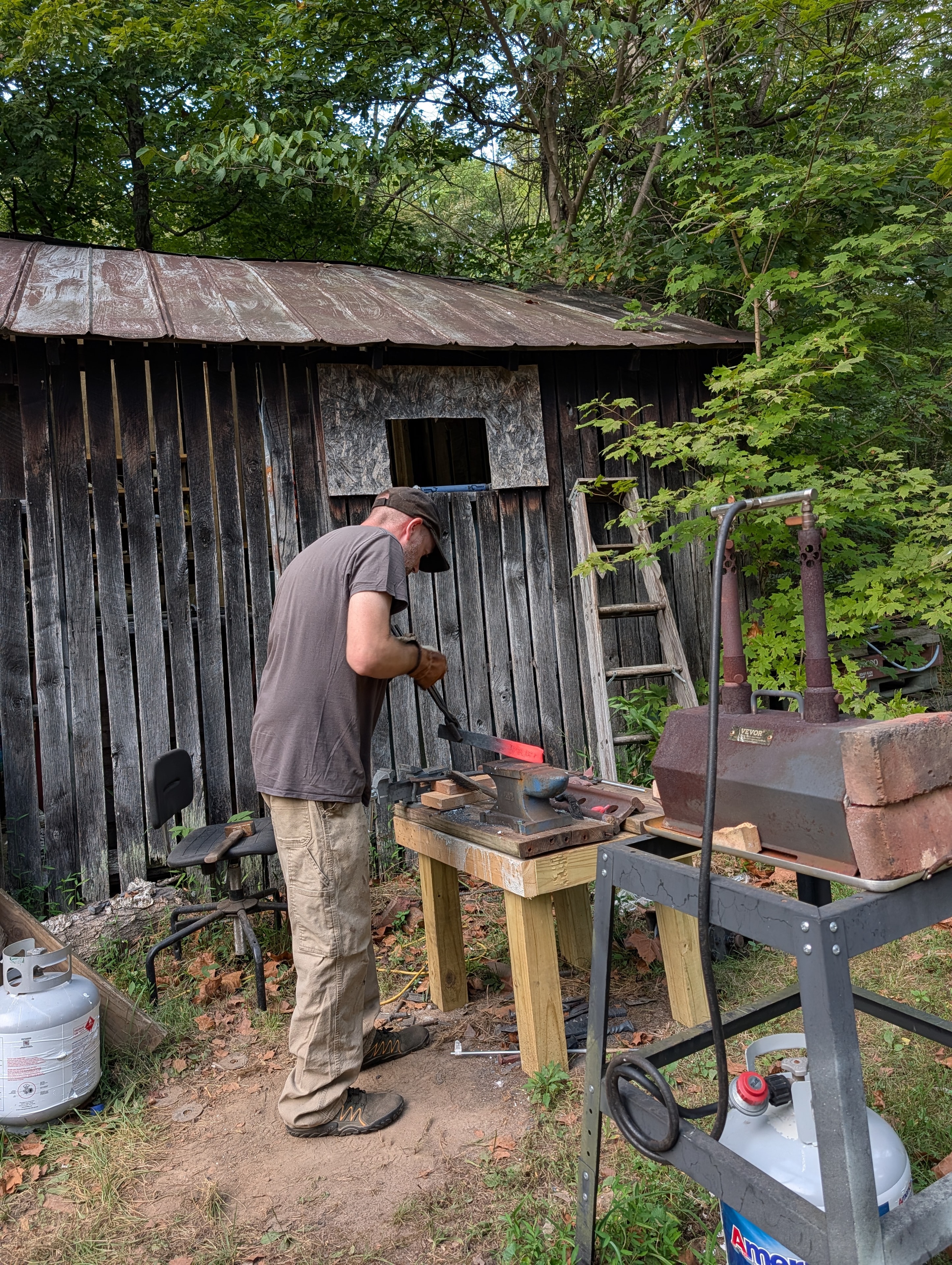 Bsharp Blacksmith working a glowing red steel blank on the outdoor anvil